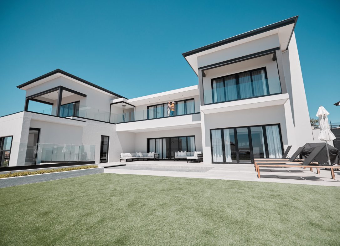 House, property and elderly couple on a balcony, relax and bonding at their dream home. Real estate.